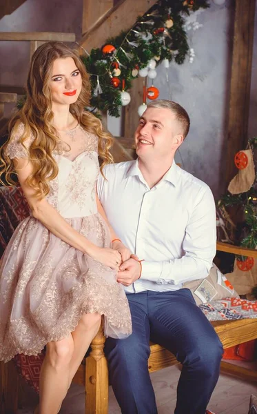 男性と女性の新年の休日の肖像画はクリスマスの贈り物で彼を驚かせた 一緒にクリスマスを祝うカップル 美しい若いカップルは居心地の良いロマンチックな場所で祝っています — ストック写真