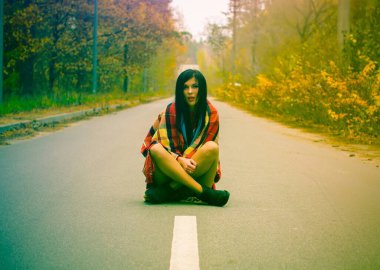 Kız ormanda dikiliyor, kırmızı bir ekose kumaşa sarılmış ve bir şeyin hayalini kuruyor. İnsanlar, yaşam tarzı, rahatlık ve rahatlama İnsanlar, gençlik, eğlence ve yaşam tarzı konsepti.