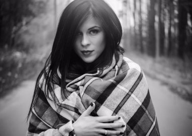 Kız ormanda dikiliyor, kırmızı bir ekose kumaşa sarılmış ve bir şeyin hayalini kuruyor. İnsanlar, yaşam tarzı, rahatlık ve rahatlama İnsanlar, gençlik, eğlence ve yaşam tarzı konsepti.