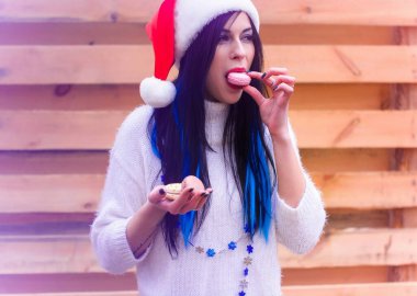 Yeni yıl şapkalı hoş bir bayan aktif olarak tatlı ve kurabiye yiyor. Yılbaşı ve Noel tatili, kızlar ve diyette karneye bağlanmak. İnsan vücudunda şeker hasarı, günlük hayatta neşe