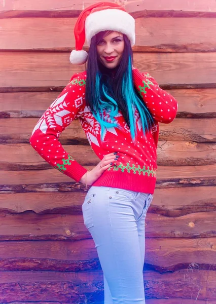 木製の背景に若い女性とクリスマスと新年のシーン 幸せな冬の休日 肖像画かわいいです女の子とともに長い髪でニットクリスマスセーターと帽子 — ストック写真