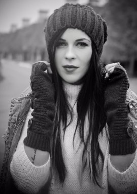 Kız kot ceket ve şort, beyaz bir kazak, örgü bir şapka ve eldiven giyiyor. Avrupa ve Amerikan kışları için günlük ve şık kıyafetler.