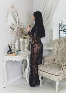 Evde Noel havası var. Güzel kilitleme. Zarif bir iç mekanda Noel ağacının yanında zarif bir kadın, kutsal Noel arifesi, hediyeler ve iyi ruh haliyle sihirli bir yeni yıl.