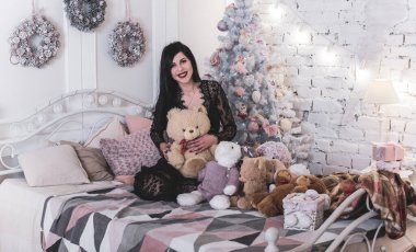 Evde Noel havası var. Güzel kilitleme. Zarif bir iç mekanda Noel ağacının yanında zarif bir kadın, kutsal Noel arifesi, hediyeler ve iyi ruh haliyle sihirli bir yeni yıl.