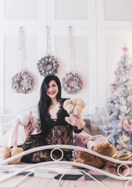 Evde Noel havası var. Güzel kilitleme. Zarif bir iç mekanda Noel ağacının yanında zarif bir kadın, kutsal Noel arifesi, hediyeler ve iyi ruh haliyle sihirli bir yeni yıl.