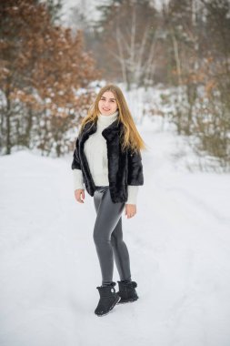 Doğada, sonbaharda, kış mevsiminde, alımlı görünümlü bir kız.