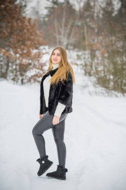 Doğada, sonbaharda, kış mevsiminde, alımlı görünümlü bir kız.