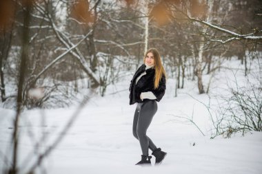 Doğada, sonbaharda, kış mevsiminde, alımlı görünümlü bir kız.