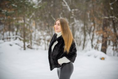 Doğada, sonbaharda, kış mevsiminde, alımlı görünümlü bir kız.