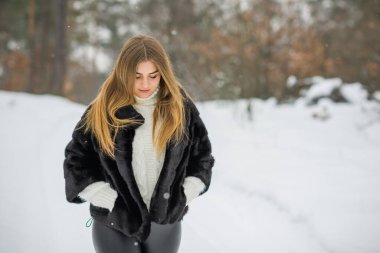 Doğada, sonbaharda, kış mevsiminde, alımlı görünümlü bir kız.