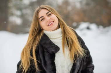 Doğada, sonbaharda, kış mevsiminde, alımlı görünümlü bir kız.