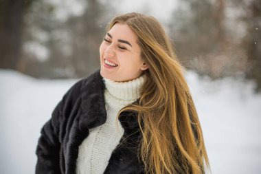 Doğada, sonbaharda, kış mevsiminde, alımlı görünümlü bir kız.