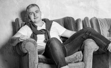 Gülümseyen mutlu bir adamın portresi. Beyaz Provence tarzıyla evde bir ekose üzerinde dinleniyor. Günlük yaşamda rahatlık, kış zamanı