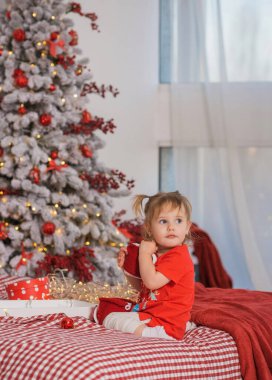 Kış tatili konsepti. İlham ve peri zamanı. Noel ağacının yanında bir çocuk. Çok hoş sıcak tatil günleri, büyülü Noel zamanı.