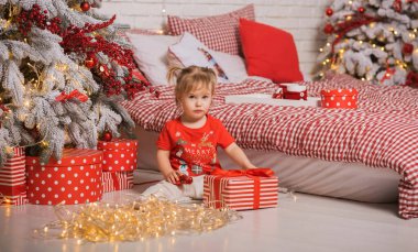 Kış tatili konsepti. İlham ve peri zamanı. Noel ağacının yanında bir çocuk. Çok hoş sıcak tatil günleri, büyülü Noel zamanı.