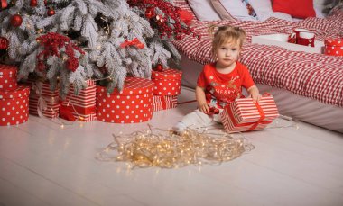 Kış tatili konsepti. İlham ve peri zamanı. Noel ağacının yanında bir çocuk. Çok hoş sıcak tatil günleri, büyülü Noel zamanı.