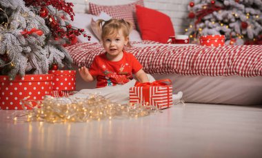 Kış tatili konsepti. İlham ve peri zamanı. Noel ağacının yanında bir çocuk. Çok hoş sıcak tatil günleri, büyülü Noel zamanı.