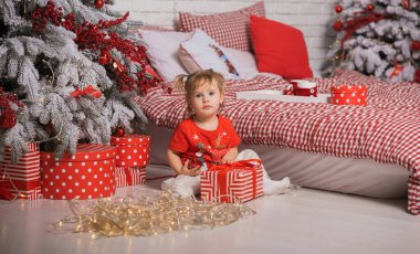 Kış tatili konsepti. İlham ve peri zamanı. Noel ağacının yanında bir çocuk. Çok hoş sıcak tatil günleri, büyülü Noel zamanı.