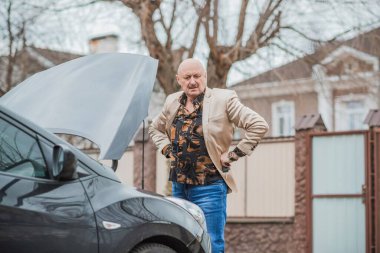 Kıdemli adamın otomobilde bir sorunu var. Araba sorunu olan olgun yaşlı bir adam, yaşam tarzı.