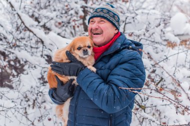 Yaşlı adam evcil hayvanlarla yürüyüşe çıktı. Pozitif yaşam tarzı ve 50-60 yıl sonra yaşam tarzı. Keyfi yerinde ve evcil hayvanla neşeli bir tatil. 