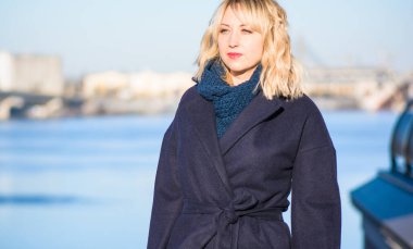 Hayat kavramı büyük şehirdeki modern kadın, yaşam tarzı vatandaşlar, ilkbahar ya da sonbahar günlerindeki kadın. Paltolu ve atkılı orta yaşlı bir kadın caddelerin ortasında yürüyor.