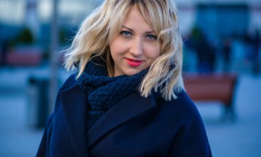 Hayat kavramı büyük şehirdeki modern kadın, yaşam tarzı vatandaşlar, ilkbahar ya da sonbahar günlerindeki kadın. Paltolu ve atkılı orta yaşlı bir kadın caddelerin ortasında yürüyor.