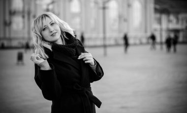 Hayat kavramı büyük şehirdeki modern kadın, yaşam tarzı vatandaşlar, ilkbahar ya da sonbahar günlerindeki kadın. Paltolu ve atkılı orta yaşlı bir kadın caddelerin ortasında yürüyor.