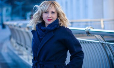 Hayat kavramı büyük şehirdeki modern kadın, yaşam tarzı vatandaşlar, ilkbahar ya da sonbahar günlerindeki kadın. Paltolu ve atkılı orta yaşlı bir kadın caddelerin ortasında yürüyor.