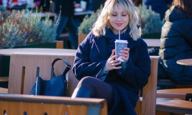 Hayat kavramı büyük şehirdeki modern kadın, yaşam tarzı vatandaşlar, ilkbahar ya da sonbahar günlerindeki kadın. Paltolu ve atkılı orta yaşlı bir kadın caddelerin ortasında yürüyor.