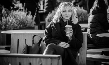 Hayat kavramı büyük şehirdeki modern kadın, yaşam tarzı vatandaşlar, ilkbahar ya da sonbahar günlerindeki kadın. Paltolu ve atkılı orta yaşlı bir kadın caddelerin ortasında yürüyor.