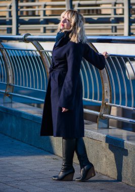 Hayat kavramı büyük şehirdeki modern kadın, yaşam tarzı vatandaşlar, ilkbahar ya da sonbahar günlerindeki kadın. Paltolu ve atkılı orta yaşlı bir kadın caddelerin ortasında yürüyor.