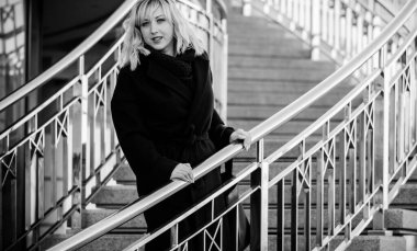 Hayat kavramı büyük şehirdeki modern kadın, yaşam tarzı vatandaşlar, ilkbahar ya da sonbahar günlerindeki kadın. Paltolu ve atkılı orta yaşlı bir kadın caddelerin ortasında yürüyor.