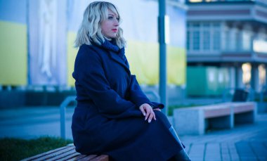 Hayat kavramı büyük şehirdeki modern kadın, yaşam tarzı vatandaşlar, ilkbahar ya da sonbahar günlerindeki kadın. Paltolu ve atkılı orta yaşlı bir kadın caddelerin ortasında yürüyor.