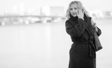 Hayat kavramı büyük şehirdeki modern kadın, yaşam tarzı vatandaşlar, ilkbahar ya da sonbahar günlerindeki kadın. Paltolu ve atkılı orta yaşlı bir kadın caddelerin ortasında yürüyor.