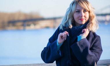 Hayat kavramı büyük şehirdeki modern kadın, yaşam tarzı vatandaşlar, ilkbahar ya da sonbahar günlerindeki kadın. Paltolu ve atkılı orta yaşlı bir kadın caddelerin ortasında yürüyor.