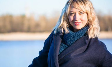 Hayat kavramı büyük şehirdeki modern kadın, yaşam tarzı vatandaşlar, ilkbahar ya da sonbahar günlerindeki kadın. Paltolu ve atkılı orta yaşlı bir kadın caddelerin ortasında yürüyor.