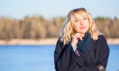 Hayat kavramı büyük şehirdeki modern kadın, yaşam tarzı vatandaşlar, ilkbahar ya da sonbahar günlerindeki kadın. Paltolu ve atkılı orta yaşlı bir kadın caddelerin ortasında yürüyor.