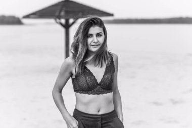 Seyahat konsepti. Sahilde genç bir kadının felsefi fotoğrafı. Kıyafetlerde minimalizm  