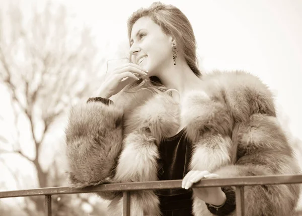 Stylish lady in a vintage style of clothes. She is dressed in a velvet dress and a light red fur coat. Style 50s in modern life