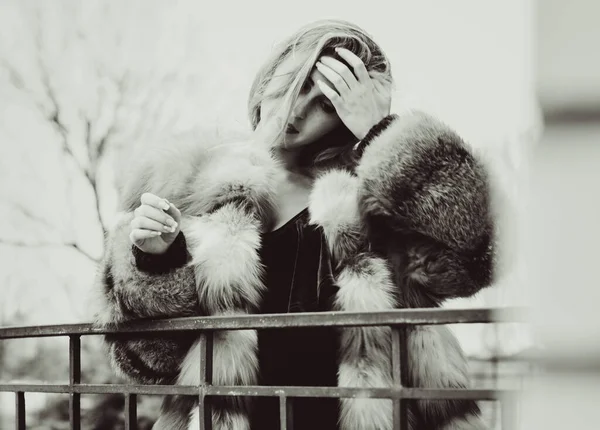 Stylish lady in a vintage style of clothes. She is dressed in a velvet dress and a light red fur coat. Style 50s in modern life