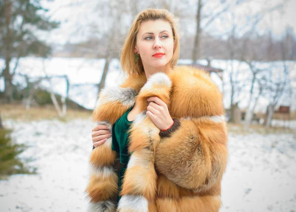 Stylish lady in a vintage style of clothes. She is dressed in a velvet dress and a light red fur coat. Style 50s in modern life