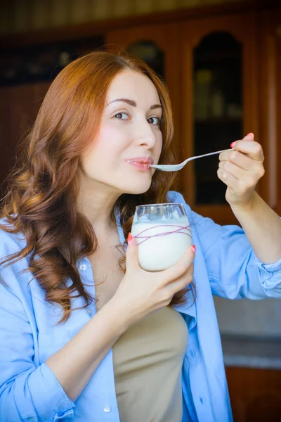 European or American woman at morning eat homemade organic yogurt with fresh berries. Homemade yogurt in girl`s hands. Health care and diet and breakfast cereal. Healthy eating and lifestyle concept