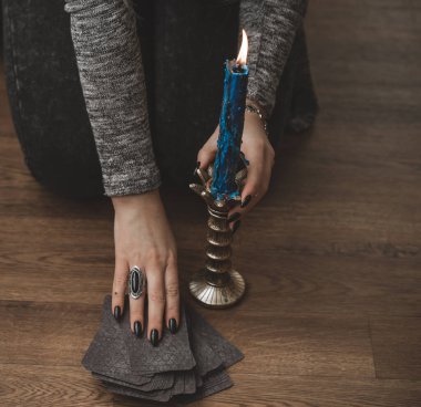 Sihirli sahne, esrarengiz konsept, falcılık ve büyü, kadın ellerinde tarot kartları ve mum.