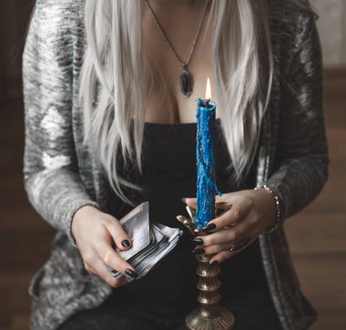 Sihirli sahne, esrarengiz konsept, falcılık ve büyü, kadın ellerinde tarot kartları ve mum.