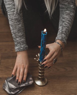 Sihirli sahne, esrarengiz konsept, falcılık ve büyü, kadın ellerinde tarot kartları ve mum.