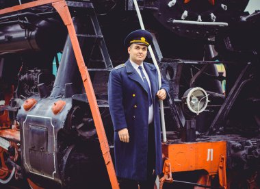 Avrupalı ya da Amerikalı tren kondüktörü bir platformda ve diğer trenlerde görevdedir. Demiryolu, buharlı trenler, klasik trenler.