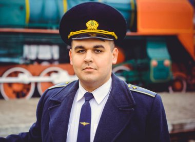 Avrupalı ya da Amerikalı tren kondüktörü bir platformda ve diğer trenlerde görevdedir. Demiryolu, buharlı trenler, klasik trenler.