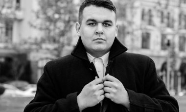 Genç ve cüsseli adam rahatlıyor ve manzaranın tadını çıkarıyor. Büyük şehir yaşamındaki tombul insanlar konsepti. Şehir merkezindeki şişman iş adamının görüntüsü