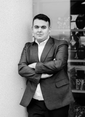 Genç ve cüsseli adam rahatlıyor ve manzaranın tadını çıkarıyor. Büyük şehir yaşamındaki tombul insanlar konsepti. Şehir merkezindeki şişman iş adamının görüntüsü