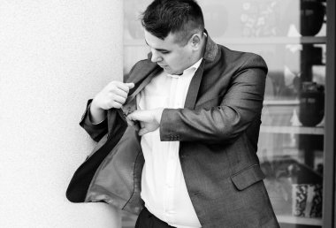 Genç ve cüsseli adam rahatlıyor ve manzaranın tadını çıkarıyor. Büyük şehir yaşamındaki tombul insanlar konsepti. Şehir merkezindeki şişman iş adamının görüntüsü